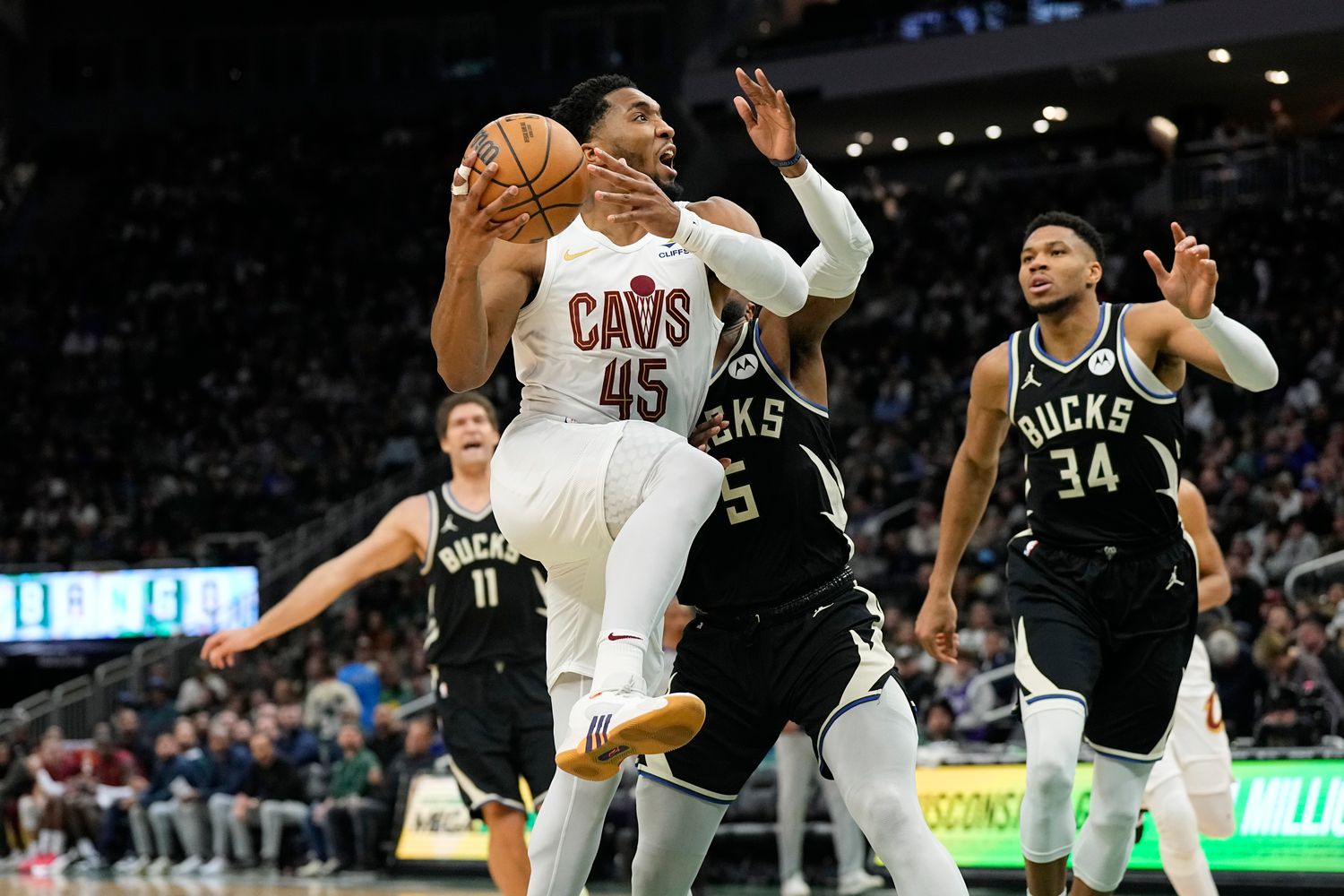 Jan 26, 2024; Milwaukee, Wisconsin, USA; Cleveland Cavaliers guard Donovan Mitchell (45) drives for the basket in front of Milwaukee Bucks guard Malik Beasley (5) during the third quarter at Fiserv Forum. Mandatory Credit: Jeff Hanisch-USA TODAY Sports